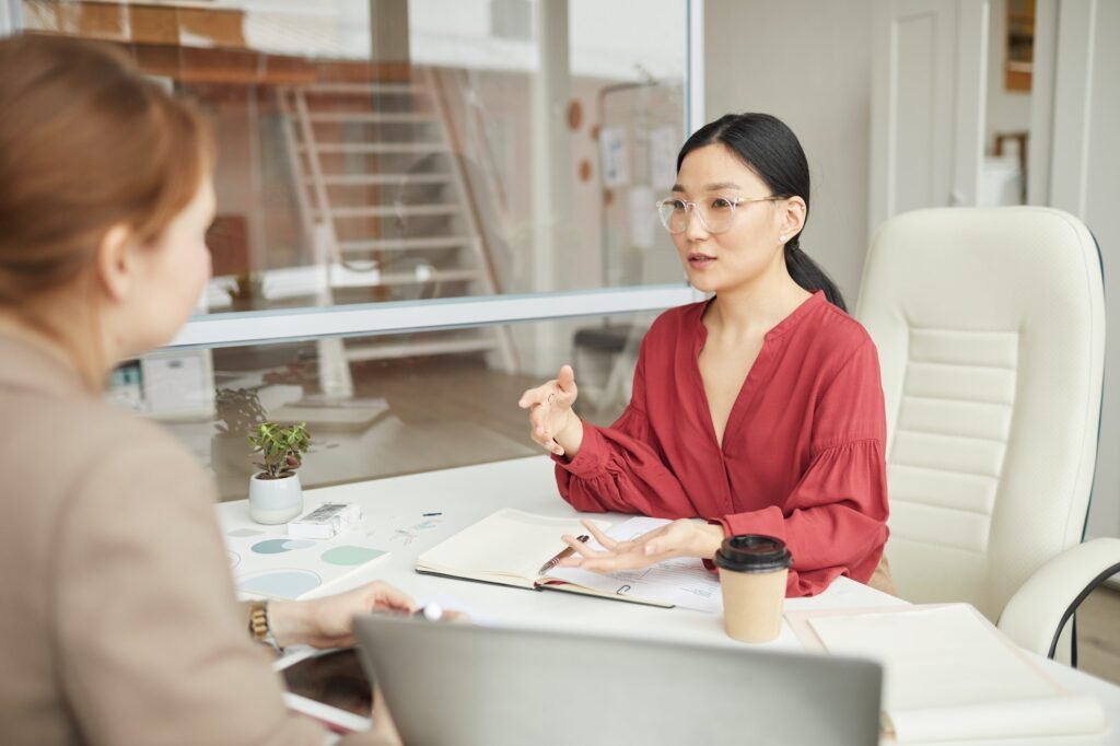 Asian Businesswoman Talking to Worker in Office